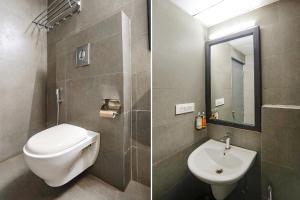 a bathroom with a toilet and a sink and a mirror at FabHotel Ramayana in Vibhuti Khand