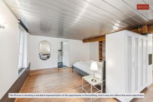1 dormitorio con cama y espejo en Affordable Living on Zurich's Edge, en Dietikon
