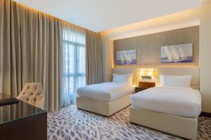 Uma cama ou camas num quarto em Riviera Rayhaan by Rotana Doha