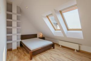 a small bedroom with a bed and two windows at Apartamenty NCNK Willa Turkusowa in Kąty Rybackie