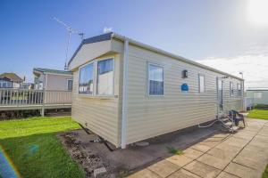 a tiny house is parked in a yard at 8 Berth Spacious Caravan By The Beach In Norfolk Ref 50059g in Great Yarmouth