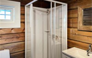 een glazen douche in de badkamer met houten wanden bij Cozy Home In Reinli With Wifi in Reinli