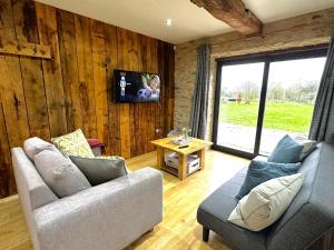 ein Wohnzimmer mit 2 Sofas und einem TV in der Unterkunft Dove House Cottages - No 1 in Oxford