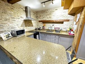 eine Küche mit Granitarbeitsplatte in einem Zimmer in der Unterkunft Dove House Cottages - No 1 in Oxford