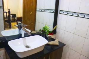 a bathroom with a white sink and a mirror at Saba Holiday Homes in Machakos