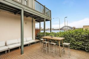 a patio with a table and chairs and a bridge at Balmain Wharf 1 bedroom Apartments in Sydney