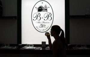 a woman eating food in front of a sign at B&B Alla Stazione in Palermo +27 photos