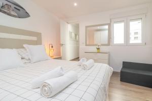 a white bedroom with a large white bed with towels on it at Centric in Palma de Mallorca