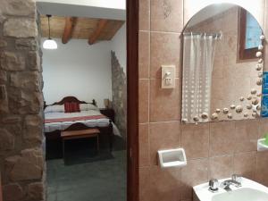 a bathroom with a sink and a bed in a room at La Casa del Indio in Tilcara
