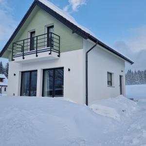 a house in a pile of snow at All Season Lasówka in Lasowka