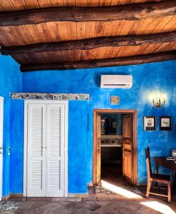 a blue house with a wooden ceiling and a door at Aeneas' Landing Resort in Gaeta