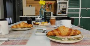 un tavolo con piatti di croissant e pane sopra di Habitaciones con encanto 