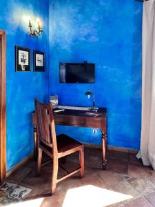 a blue room with a wooden desk with a chair at Aeneas' Landing Resort in Gaeta
