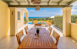 einen Holztisch auf einer Terrasse mit Meerblick in der Unterkunft Splendid Kefalonia Villa - 3 Bedrooms - Villa Mandola - Great Sea and Mountain Views - Trapezaki in Kefalonia