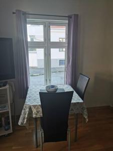 mesa y sillas con mesa y ventana en Nice 1-bedroom apartment in Heart of the City, en Stavanger