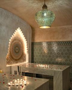 卡薩布蘭卡的住宿－藝術宮Spa套房酒店，一间设有一张桌子、蜡烛和吊灯的房间