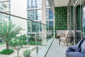 d'un balcon avec des chaises et des plantes dans un bâtiment. dans l'établissement HiGuests - Magnificent Apt with Panoramic Views All Around, à Dubaï