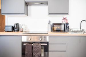 a kitchen with a stove and a microwave at Fancy 2-Bedroom Apartment with 2 Bathrooms in Bradford Town Centre in Bradford