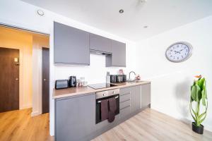 a kitchen with a sink and a clock on the wall at Fancy 2-Bedroom Apartment with 2 Bathrooms in Bradford Town Centre in Bradford