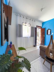 sala de estar con paredes azules y sofá en Bella Vida Casa Azul en Morro de São Paulo