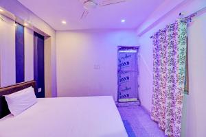 a bedroom with a bed and a door with a curtain at OYO Moon Sez in Auraiya