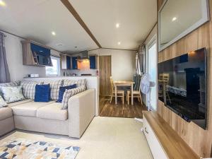 a living room with a couch and a dining room at Lovely 6 Berth Caravan With Decking And Wifi In Kent, Ref 47017c in Whitstable