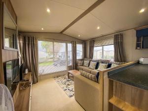 een woonkamer met een bank en een tv bij Lovely 6 Berth Caravan With Decking And Wifi In Kent, Ref 47017c in Whitstable