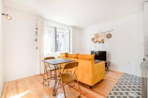 - un salon avec un canapé jaune et une table dans l'établissement Bonfim Cozy Home Studio, à Porto