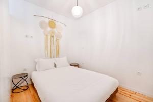 - une chambre avec un grand lit blanc et des draps blancs dans l'établissement Bonfim Cozy Home Studio, à Porto