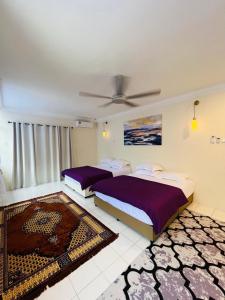 a bedroom with two beds and a ceiling fan at D Riad Ipoh Homestay l Home Cinema l 300MBPS in Ipoh