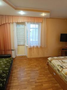 um quarto com uma cama e uma janela com cortinas em Cozy apartments on Lushpy Avenue em Sumy