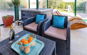 a table with a bowl of oranges on a patio at Nice Home In Kremena With 3 Bedrooms, Wifi And Outdoor Swimming Pool in Klek
