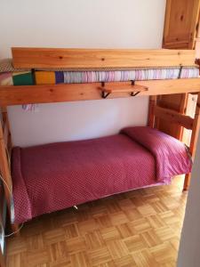 a room with two bunk beds and a red bed underneath it at Ciasa de Carla in Masarè
