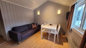 a living room with a couch and a table at Øen Turistsenter Cottages in Geilo