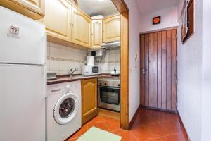a kitchen with a refrigerator and a washer at Akisol Caparica Alive in Costa da Caparica