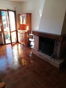 a living room with a fireplace and a tile floor at Ciasa de Carla in Masarè