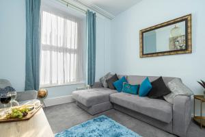 ein Wohnzimmer mit einem Sofa und einem Tisch in der Unterkunft St James Place 4 bed Apt with JOIVY in Plymouth
