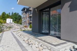 VacationClub - Spokojna 24A Apartament D1 في فيسلا: منزل به ممشى حجري بجوار مبنى