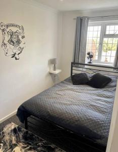 a bedroom with a bed and a window at Spacious 5 Bedroom House- Harry potter world & London in Watford