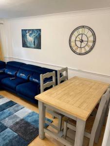沃特福德的住宿－Spacious 5 Bedroom House- Harry potter world & London，客厅配有桌子和蓝色沙发