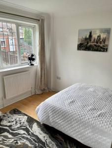 biała sypialnia z łóżkiem i oknem w obiekcie Spacious 5 Bedroom House- Harry potter world & London w mieście Watford