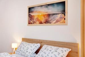 a picture hanging above a bed with a bed sidx sidx sidx at Ferienwohnung Alpenveilchen in Grainau
