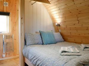a bedroom with a bed in a log cabin at Lowside Farm Glamping in Troutbeck
