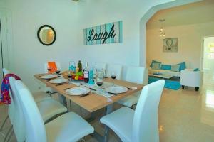 a dining room with a table and white chairs at Villa Blau in Alcudia