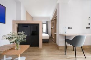 numa I Goya Apartments في مدريد: غرفة معيشة مع طاولة وغرفة نوم