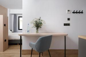 numa I Goya Apartments في مدريد: طاولة مع إناء من الزهور وزجاجة من الماء