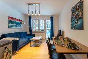 un salon avec un canapé bleu et une table dans l'établissement Apartament Reglowy Raj - z prywatnym parkingiem by SpaceApart, à Szklarska Poręba 15 autres photos