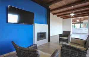 sala de estar con pared azul, TV y sillas en 3 Bedroom Gorgeous Home In Perdifumo, en Perdifumo