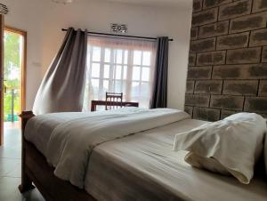 a bedroom with a large bed with a brick wall at Babylon Lodge in Marangu