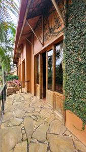 a stone walkway leading to a building with windows at Babylon Lodge in Marangu